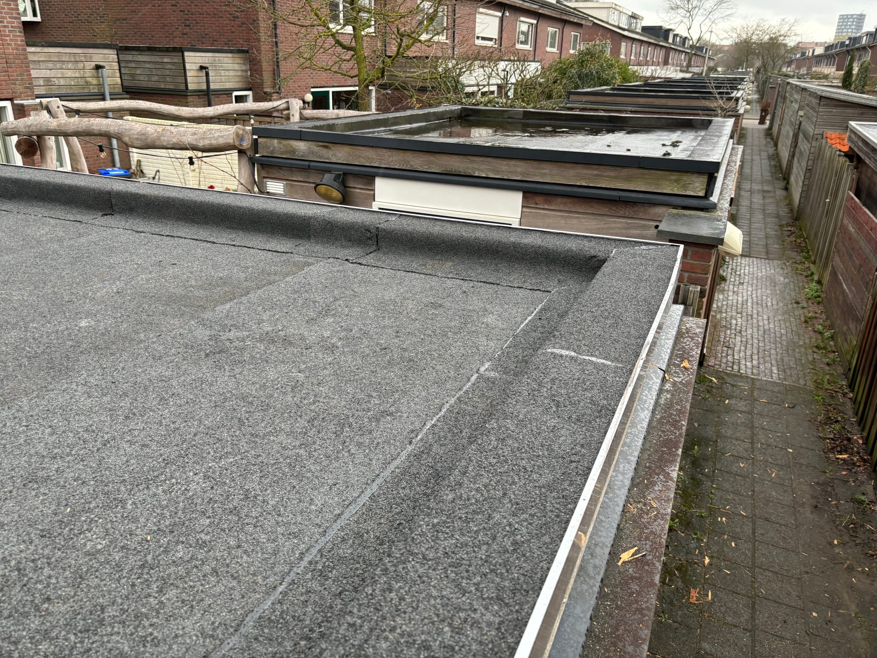 Strak afgewerkte dakrand van een plat dak met nieuwe bitumen dakbedekking