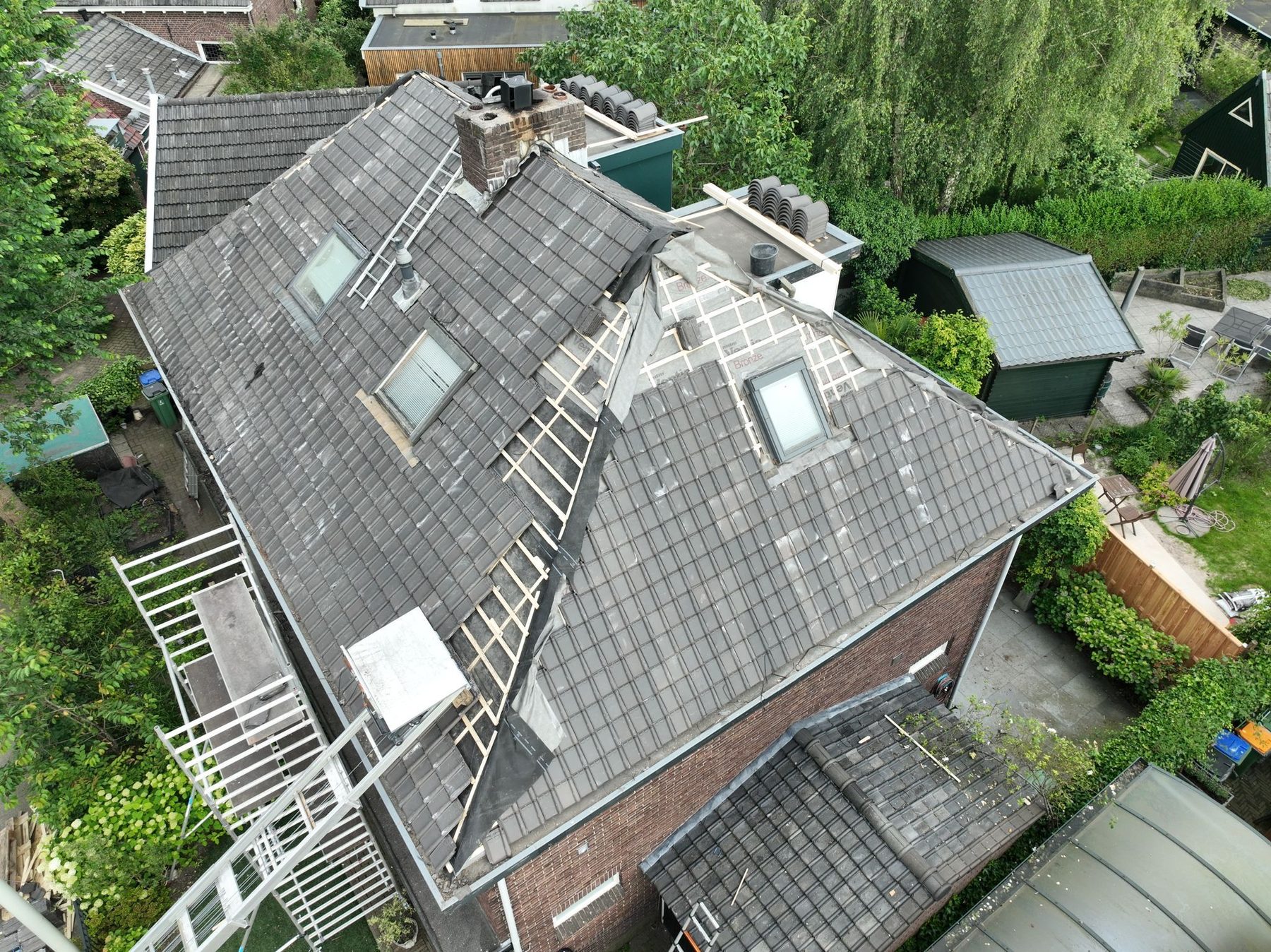 Dakinspectie van een pannendak met dakkapellen vanaf hoogte